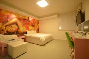 a bedroom with a bed and a painting of a woman at Jeonju Cherevill Motel in Jeonju