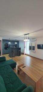 a living room with a green couch and a table at ApartHotel Dominic Residence in Alba Iulia