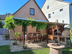 a patio with a table and chairs in front of a house at Mözsi Apartman Tolna in Tolna