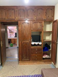 a wooden cabinet with a tv in a room at Amzdogh in Sidi Ifni