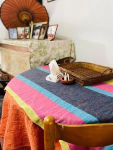 a bed with a colorful blanket and a basket on it at No 06 Veediya Bandara Lane Bahirawakanda in Kandy