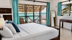 a bedroom with a bed and a view of the ocean at Hotel Villa de Pescadores in Río Lagartos