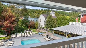 a balcony with a pool and chairs and a resort at Green Mountain Inn in Stowe