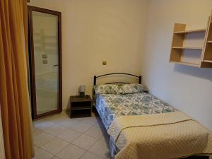 a small bedroom with a bed and a mirror at Sweet Home Nea Roda! in Nea Roda