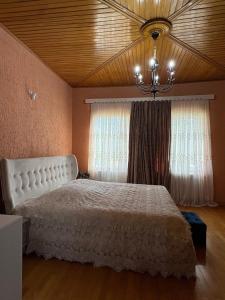 a bedroom with a white bed and a chandelier at Dream House in Batumi +38 photos