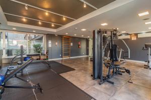 a gym with treadmills and equipment in a room at Loft Centralíssimo com Garagem in Pelotas