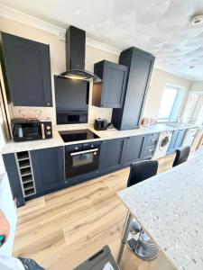 a kitchen with blue cabinets and a counter top at Channel side in Pevensey