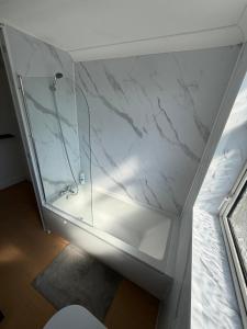 a bathroom with a glass shower and a toilet at Channel side in Pevensey