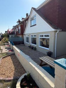 a house with a bench in front of it at Channel side in Pevensey