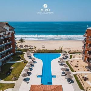 an aerial view of a resort with a pool and the beach at vivo resort in Chano