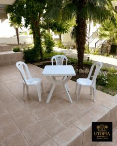 a white table and two chairs on a patio at Utopia Apartment in Kallithea Halkidikis