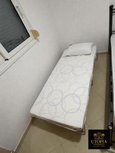 a bed in a room next to a window at Utopia Apartment in Kallithea Halkidikis