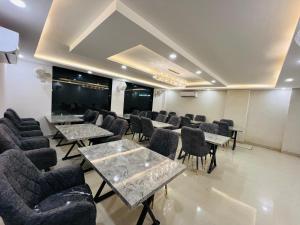 a waiting room with tables and chairs and a projection screen at Hotel LA Costa, A Luxury Hotel In Haridwar in Haridwār +28 photos