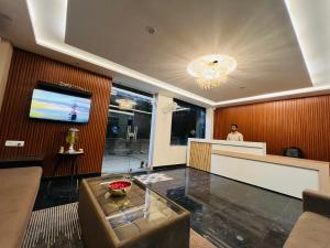 a lobby with a reception desk and a man in the background at Hotel LA Costa, A Luxury Hotel In Haridwar in Haridwār