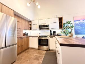eine Küche mit weißen Schränken und einem Edelstahlkühlschrank in der Unterkunft Summit View Collection in Kimberley