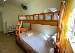 two bunk beds in a room with a window at Beach Walk Apartment with Private Garden & Wifi in Grand-Baie