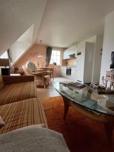 a living room with a couch and a glass table at Haus-Moewe-Jonathan-Wohnung-1 in Morsum