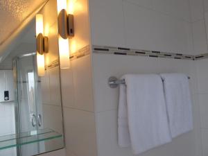 a bathroom with white towels and a mirror at Haus-Moewe-Jonathan-Wohnung-1 in Morsum