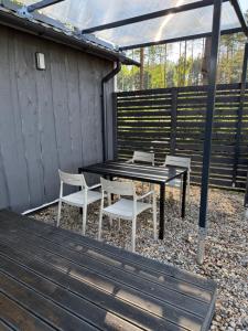 a black table and two white chairs on a patio at Pussala Latgalē in Ezerukiņi