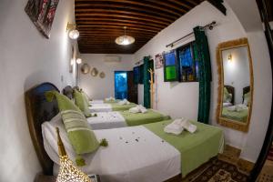 a group of four beds in a room at Riad Al Fanouss in Fez