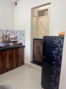 a kitchen with a refrigerator next to a counter at Ujjain Sparsh Stays in Ujjain