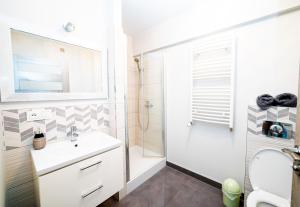 a bathroom with a white sink and a shower at Central Apartments Premium in Goleniów
