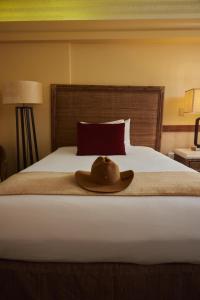a hat is sitting on top of a bed at The Equus in Honolulu
