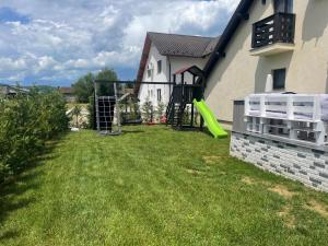 a yard with a playground with a green slide at Cazare Băile Figa -The Home DRM in Beclean