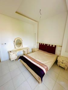 a bedroom with a bed and a table and a mirror at Jenhani chokri in Kelibia