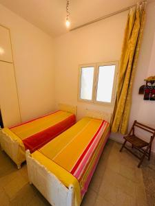 two beds in a room with a window at Jenhani chokri in Kelibia +1 photo