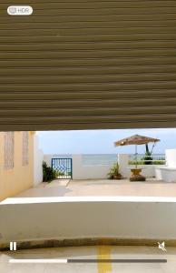 a view of a patio with an umbrella and the ocean at Jenhani chokri in Kelibia