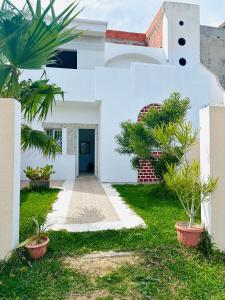 a white house with plants in the yard at Jenhani chokri in Kelibia