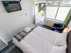 a bedroom with a bed and a tv on the wall at Walnut Studio - Self Contained One-Bed Studio Flat in Oxford