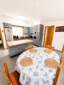 a kitchen with a table and some chairs and a kitchen with a table andheastern at Apartamento As Caldelas in O Grove