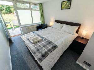 a bedroom with a bed with two towels on it at Walnut Studio - Self Contained One-Bed Studio Flat in Oxford