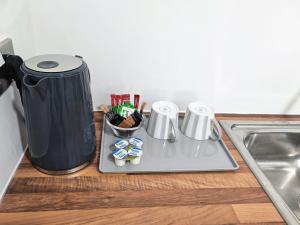 a counter top with a tray with a coffee pot and utensils at Walnut Studio - Self Contained One-Bed Studio Flat in Oxford
