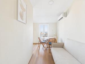 a living room with a white couch and a table at 2BR Terrace with Tagus View - Air-Conditioned | By Airnest in Lisbon