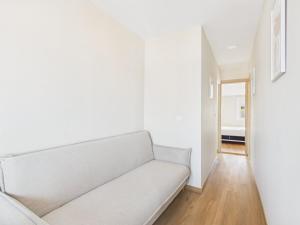 a living room with a white couch and a hallway at 2BR Terrace with Tagus View - Air-Conditioned | By Airnest in Lisbon