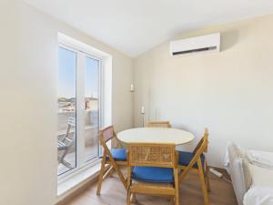 a dining room with a table and chairs and a window at 2BR Terrace with Tagus View - Air-Conditioned | By Airnest in Lisbon +9 photos