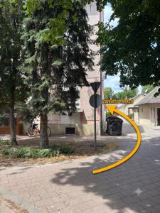 a yellow hose on a street next to a building at Welcome Ma-Ko in Makó