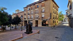 a statue in the middle of a street with a building at Hostal Lizana 2 in Huesca
