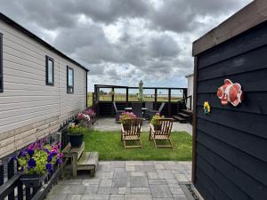 a patio with a table and chairs and flowers at Prachtig chalet de ZEE STER in Westerland
