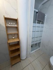 a bathroom with a shower and a wooden shelving unit at Jimaguas in Tamaduste +20 photos