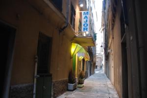 un callejón con una señal en el lateral de un edificio en Hotel Major, en Génova