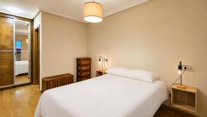 a bedroom with a white bed and a window at Apto Llanes Bajo con terraza - Casa Juanín in Llanes +19 photos