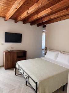 a bedroom with a bed and a flat screen tv at B&B Casa Olivia in Gardone Riviera