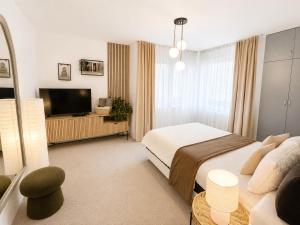 a bedroom with a bed and a flat screen tv at Guest House Rila in Govedartsi