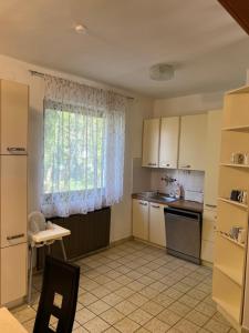 a kitchen with a window and a table and a sink at Aniiza apartman in Örvényes