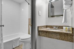 a bathroom with a toilet and a sink and a bath tub at Harvest Drive Family Inn - Renovated Rooms in Gordonville