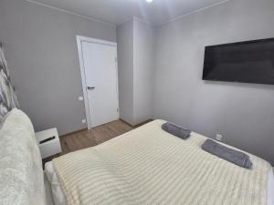a bedroom with a bed and a flat screen tv at Like home in Narva